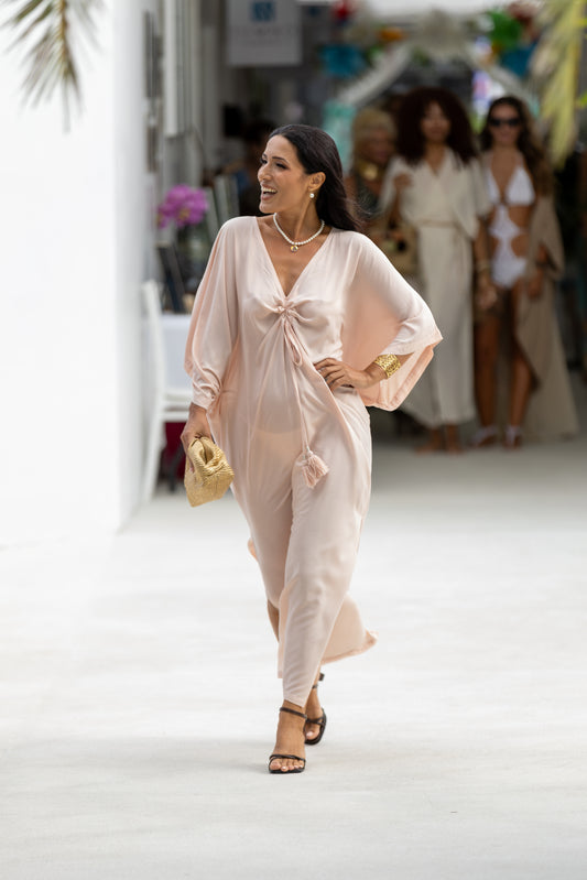 Woman in a light pink Mina Essence Horizon Kaftan walking on the runway.